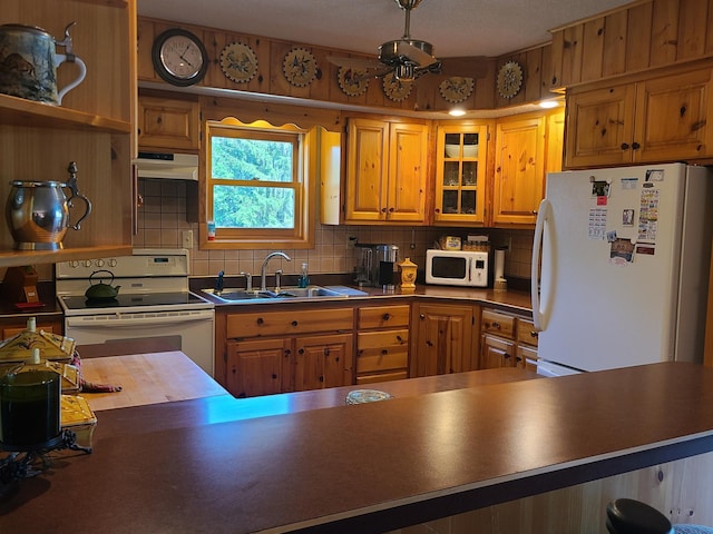 kitchen featuring white appliances, tasteful backsplash, and sink