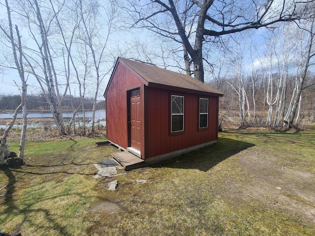 view of outdoor structure with a lawn and a water view