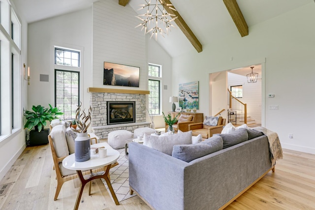 living room with beamed ceiling, a notable chandelier, a fireplace, high vaulted ceiling, and light hardwood / wood-style flooring