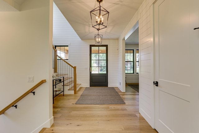 entryway with an inviting chandelier and light wood-type flooring