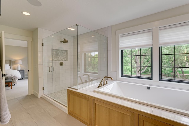 bathroom with shower with separate bathtub and tile floors