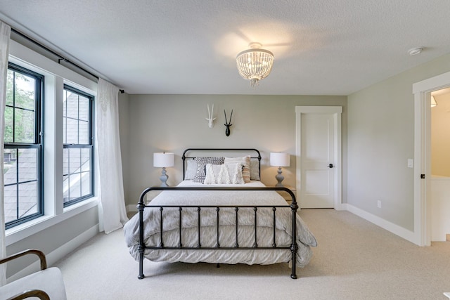 carpeted bedroom featuring an inviting chandelier and a textured ceiling