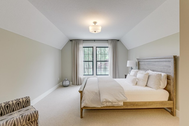 bedroom with carpet, vaulted ceiling, and a textured ceiling