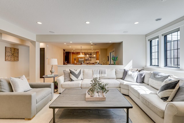 living room with light colored carpet and an inviting chandelier