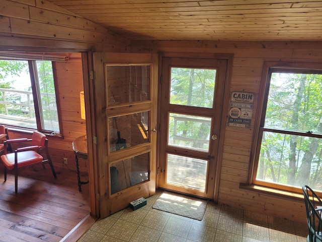 doorway with wood ceiling, light hardwood / wood-style flooring, wood walls, and vaulted ceiling