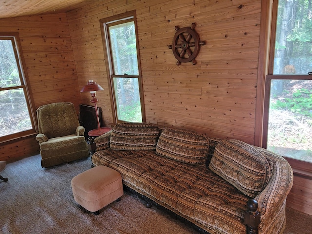 carpeted living room with wooden walls