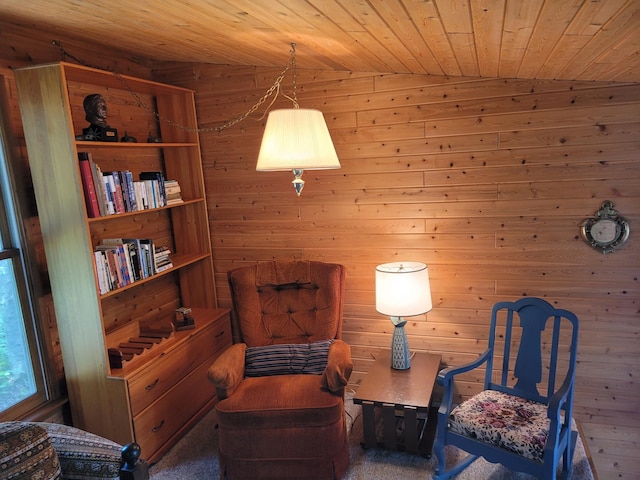 sitting room with wooden ceiling, wood walls, and dark carpet