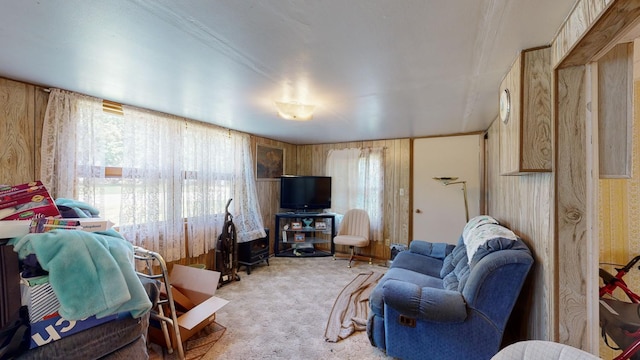 carpeted living room featuring wooden walls