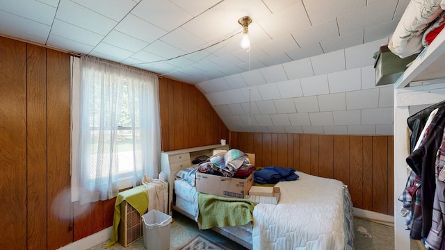 bedroom featuring carpet, wood walls, lofted ceiling, and multiple windows