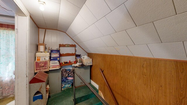 additional living space featuring wood walls and lofted ceiling