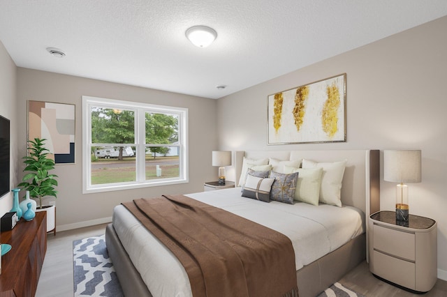 bedroom featuring wood-type flooring and a textured ceiling