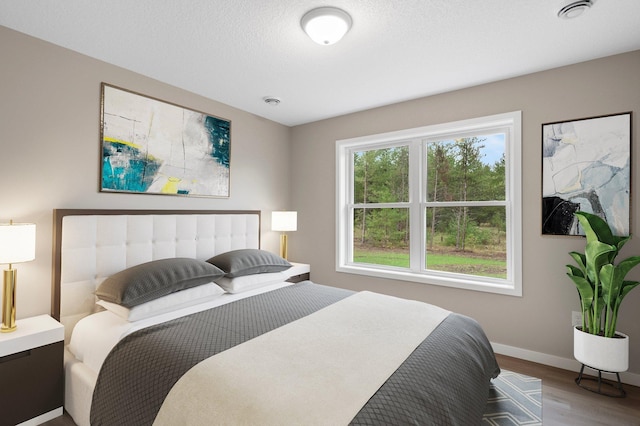 bedroom featuring a textured ceiling and hardwood / wood-style flooring