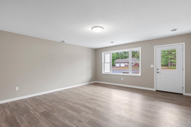 unfurnished room featuring hardwood / wood-style flooring and a textured ceiling