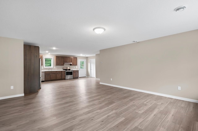 unfurnished living room featuring hardwood / wood-style floors and a textured ceiling