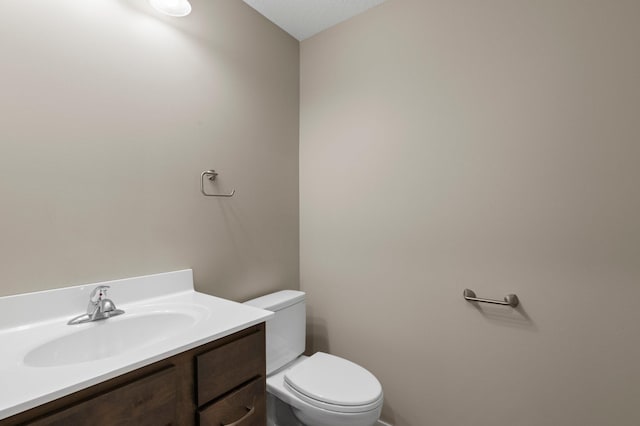 bathroom featuring toilet, vanity, and a textured ceiling