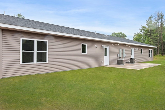 rear view of property featuring a yard, a patio, and cooling unit