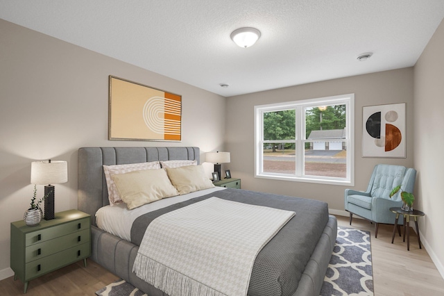 bedroom featuring light wood-type flooring and a textured ceiling