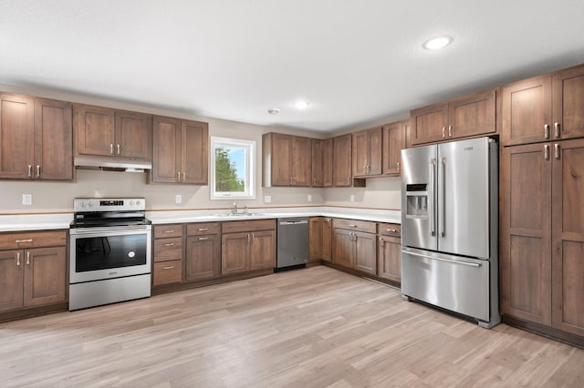 kitchen featuring light wood-type flooring, appliances with stainless steel finishes, and sink