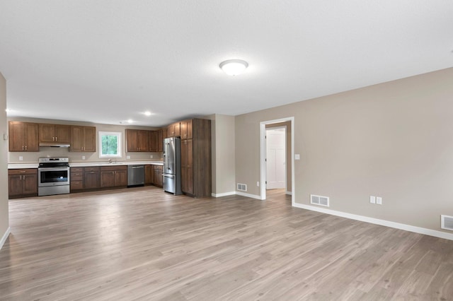 kitchen with stainless steel appliances, light hardwood / wood-style floors, and sink