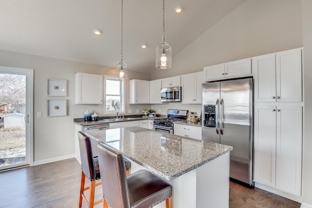 kitchen featuring a center island, hanging light fixtures, dark wood-type flooring, and stainless steel appliances