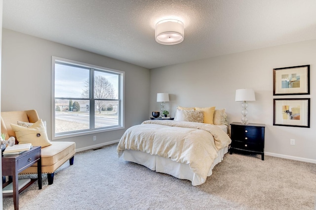 bedroom with light carpet, multiple windows, and a textured ceiling