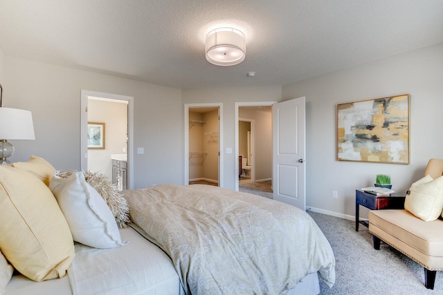 bedroom with light colored carpet, ensuite bathroom, a spacious closet, and a closet