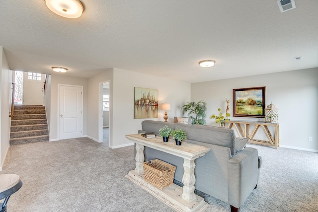 carpeted living room featuring a textured ceiling