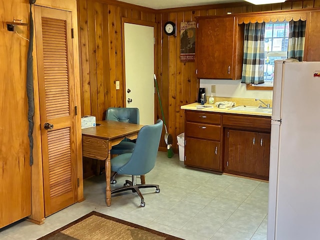 office area featuring sink, wooden walls, and ornamental molding