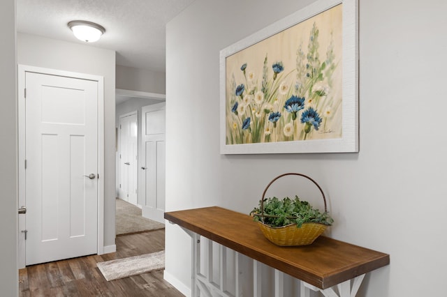 hall featuring a textured ceiling and dark hardwood / wood-style flooring