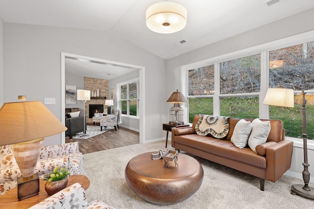 living room featuring a fireplace, hardwood / wood-style floors, and vaulted ceiling