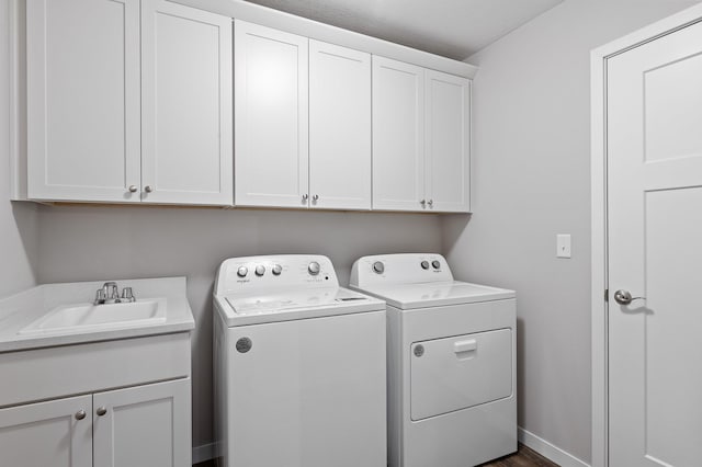 laundry room with washer and dryer, sink, cabinets, and a textured ceiling