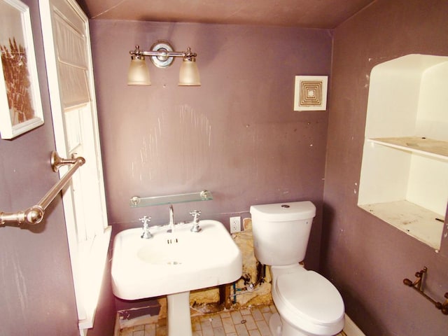 bathroom featuring tile flooring and toilet