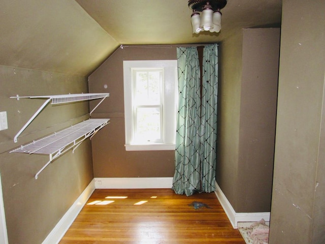 spacious closet with light hardwood / wood-style flooring and vaulted ceiling