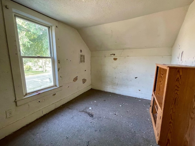 bonus room featuring a textured ceiling and vaulted ceiling