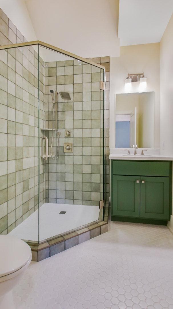 bathroom featuring vanity, toilet, a shower with door, and tile patterned floors