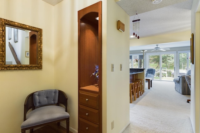 hall featuring carpet floors and a textured ceiling