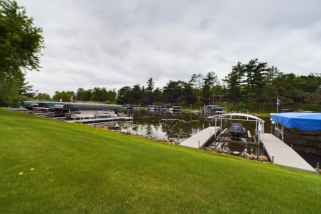 dock area with a lawn and a water view