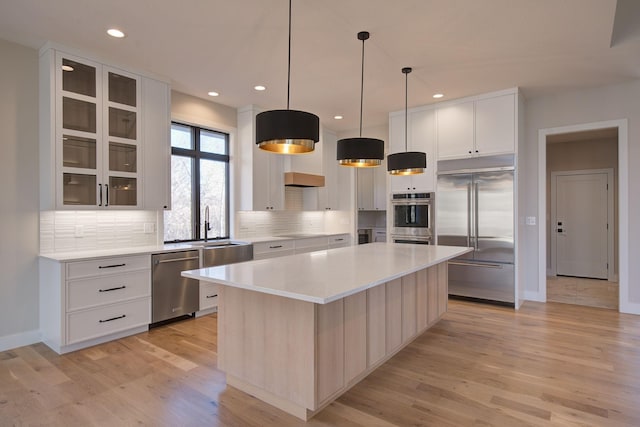 kitchen with a sink, decorative backsplash, a center island, and stainless steel appliances