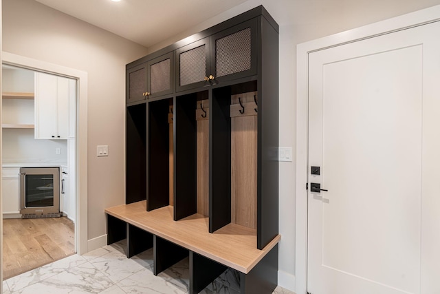 mudroom with baseboards, wine cooler, and marble finish floor