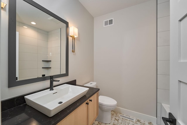 full bath featuring vanity, toilet, baseboards, and visible vents