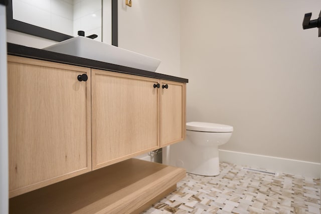 bathroom featuring baseboards and toilet