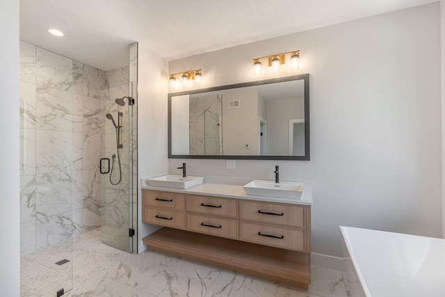 bathroom with a marble finish shower, marble finish floor, a freestanding tub, and a sink