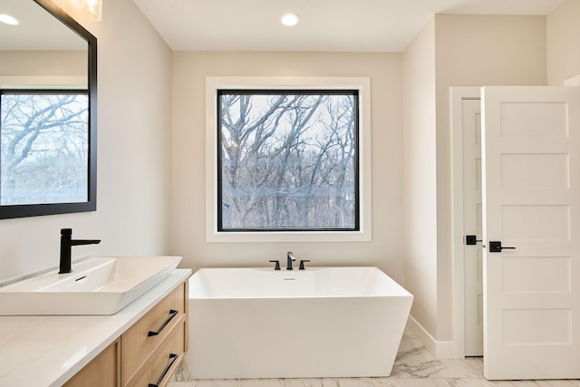 full bath featuring a wealth of natural light, recessed lighting, marble finish floor, and a freestanding bath