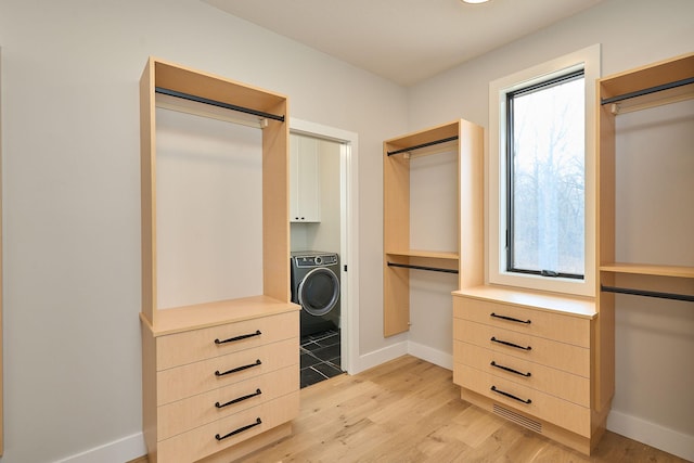 spacious closet featuring light wood-style flooring, washer / clothes dryer, and visible vents