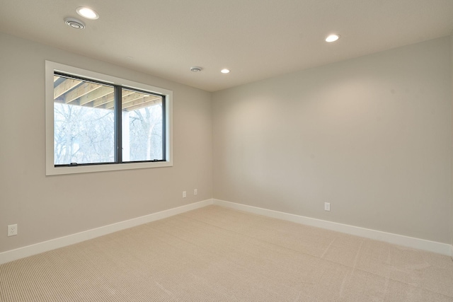 empty room featuring recessed lighting, baseboards, and light colored carpet