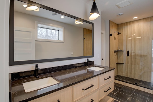 bathroom with double vanity, recessed lighting, a stall shower, and a sink