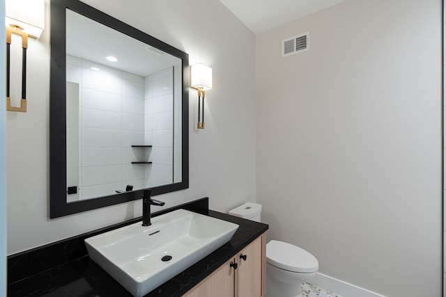 bathroom featuring visible vents, baseboards, toilet, and vanity