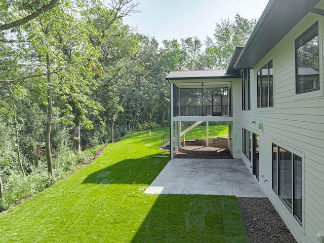 view of yard featuring a sunroom and a patio area