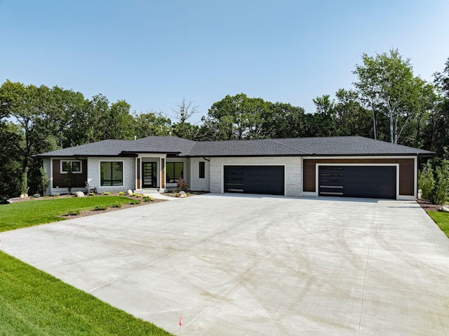 view of front of property with brick siding, concrete driveway, a garage, and a front yard