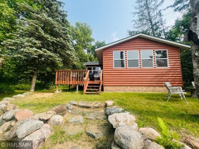 view of side of home with a deck and a lawn